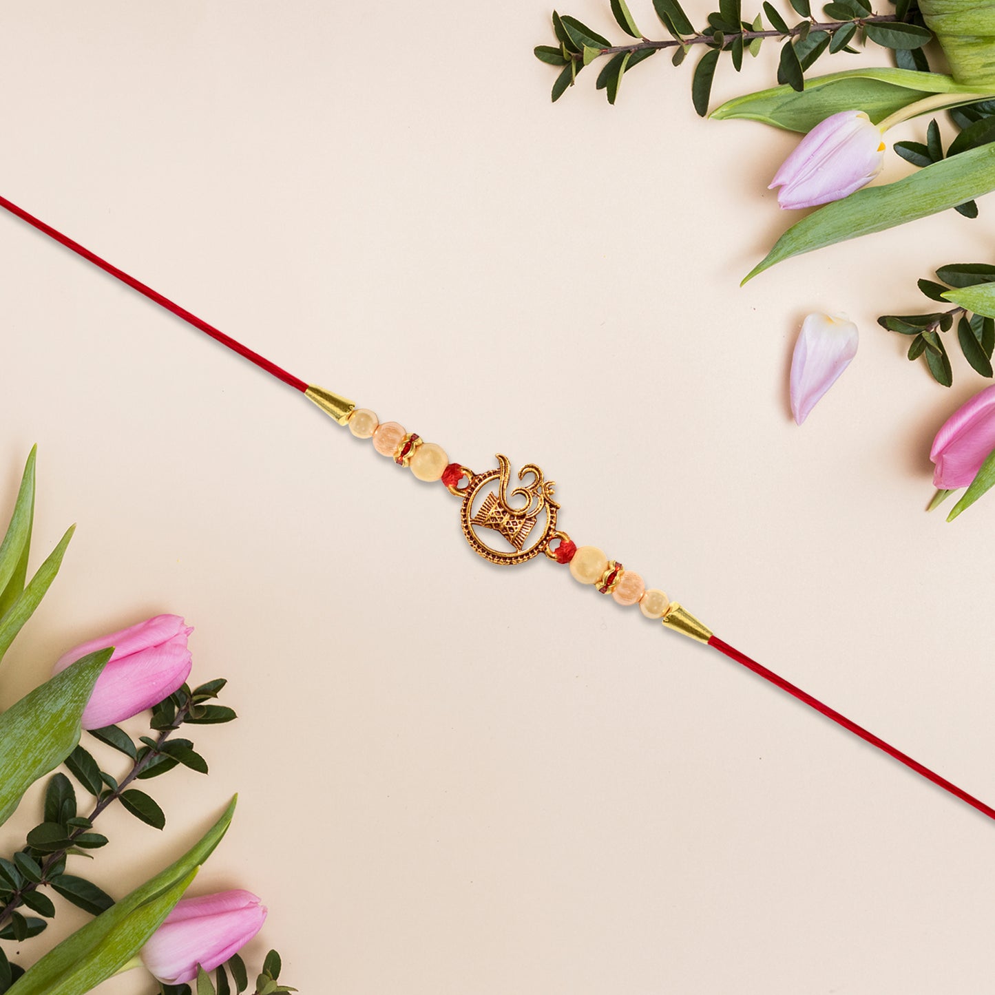 Designer Religious Rakhi With Golden Om And Swastik Motif And Pearl Beads On Red Thread