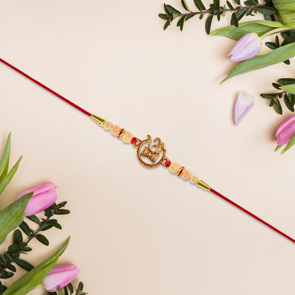 Designer Religious Rakhi With Golden Om And Swastik Motif And Pearl Beads On Red Thread