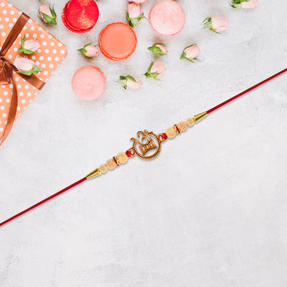 Designer Religious Rakhi With Golden Om And Swastik Motif And Pearl Beads On Red Thread