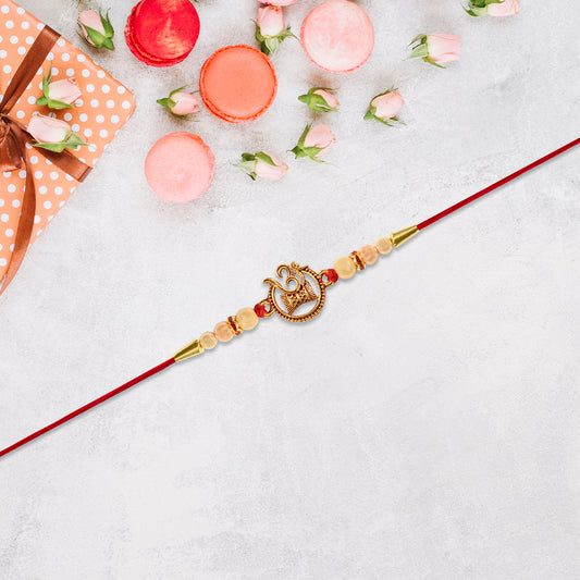 Designer Religious Rakhi With Golden Om And Swastik Motif And Pearl Beads On Red Thread